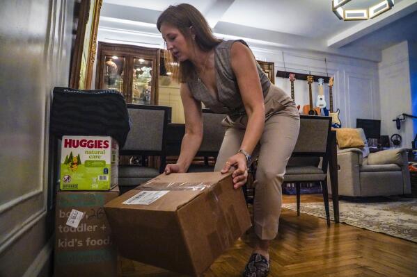 Jessica Ray moves deliveries from UPS, including baby food and diapers for her child, in her apartment on Friday, May 12, 2023, in New York. Ray, who relies on delivery for virtually everything, said she is concerned about delays in deliveries should UPS workers strike. (AP Photo/Bebeto Matthews)
