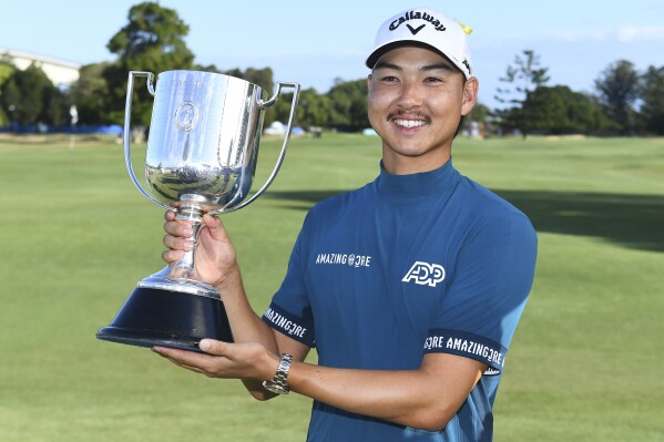 Australia's Min Woo Lee holds his trophy after winning the Australian PGA Championship in Brisbane, Sunday, Nov. 26, 2023. (Jono Searle/AAP Image via AP)
