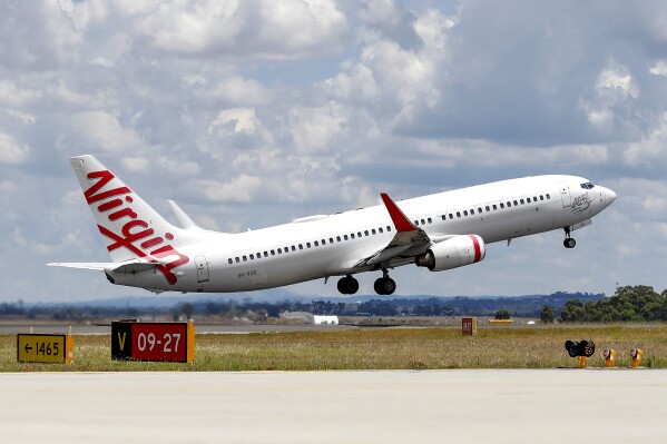 A Virgin Airlines plane takes from Melbourne Airport in Melbourne, Australia, on Jan. 31, 2022. A man accused of running naked down the aisle of an Australian domestic flight on Monday, May 27, 2024, knocking down a flight attendant and forcing the plane to turn back, has been arrested by police at the airport. (Con Chronis/AAP Image via AP)