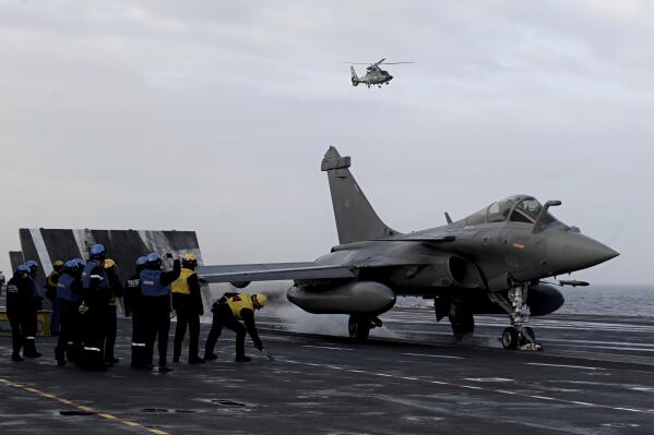 Staff look at a Rafale jet fighter about to take off the French aircraft carrier Charles de Gaulle at sea, off the coast of the city of Hyeres on Thursday Jan. 23, 2020. Croatia has decided to purchase 12 used French Rafale fighter jets in a deal worth nearly one billion euros to replace its aging fleet of Soviet-era aircraft and strengthen its air force amid still lingering tensions in the Balkans. ( Philippe Lopez, Pool via AP)