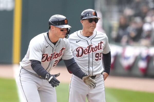 Detroit Tigers' Spencer Torkelson, left, and first base coach Anthony Lapoce look to the dugout after Torkelson's RBI single off Chicago White Sox starting pitcher Michael Soroka during the first inning of a baseball game Saturday, March 30, 2024, in Chicago. (AP Photo/Charles Rex Arbogast)