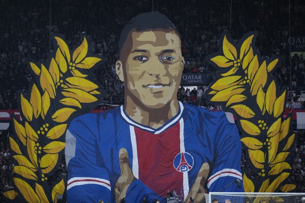 A giant painting depicting PSG's Kylian Mbappe is displayed before the French League One soccer match between Paris Saint-Germain and Toulouse at the Parc des Princes stadium in Paris, Sunday, May 12, 2024. (AP Photo/Christophe Ena)