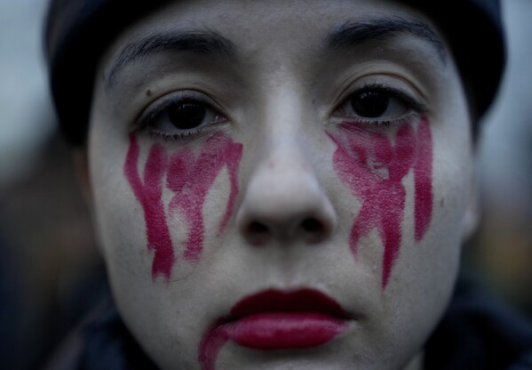 A woman with a face painted in the color of blood attends a protest in front of the Russian embassy in Berlin, Germany, Friday, Feb. 16, 2024. (AP Photo/Ebrahim Noroozi)