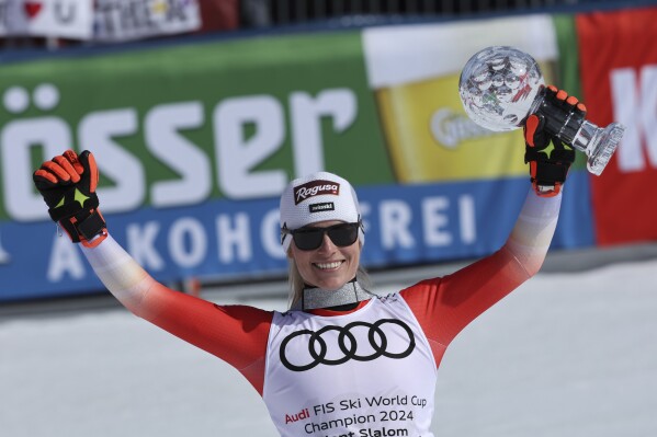 Switzerland's Lara Gut Behrami holds up the trophy for the alpine ski, women's World Cup giant slalom discipline, in Saalbach, Austria, Sunday, March 17, 2024. (AP Photo/Marco Trovati)