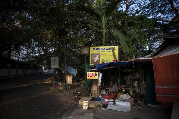 Rajan, who only uses one name, sits in his home in a forest in the heart of the city in Kochi, southern Kerala state, India, March 3, 2023. For nearly sixty years, Rajan has lived comfortably among the trees, then the surrounding city of Kochi boomed as the state's financial capital and swallowed up once-protected green areas and Rajan's former home. (AP Photo/R S Iyer)