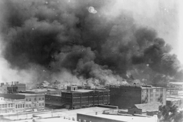 FILE - In this 1921 image provided by the Library of Congress, smoke billows over Tulsa, Okla. The state of Oklahoma says it is unwilling to participate in settlement discussions with survivors who are seeking reparations for the 1921 Tulsa Race Massacre and that a Tulsa County judge properly dismissed the case in July 2023. The Oklahoma attorney general's litigation division filed its response Monday, Aug. 14, 2023, with the Oklahoma Supreme Court. (Alvin C. Krupnick Co./Library of Congress via AP, File)