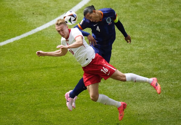 Poland's Adam Buksa, left and Virgil van Dijk of the Netherlands challenge for the ball during a Group D match between Poland and the Netherlands at the Euro 2024 soccer tournament in Hamburg, Germany, Sunday, June 16, 2024. (AP Photo/Petr Josek)