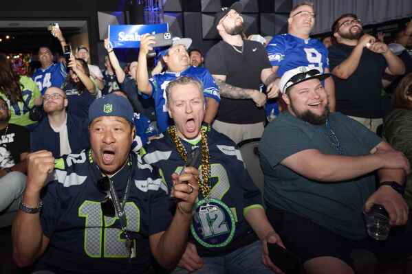 Seattle Seahawks fans react to the team's pick of North Dakota State OL Grey Zabel at No. 18 at an NFL football draft party at the Museum of Pop Culture, Thursday, April 24, 2025, in Seattle. (AP Photo/John Froschauer)