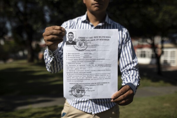 Diego Fernando Espitia, the cousin of Colombian soldier Oscar Arley Triana, who disappeared in the war in Ukraine, shows his cousin's entry papers into the Ukrainian army, in Bogotá, Colombia, Wednesday, Jan. 10, 2024. Espitia lost contact with his cousin, who joined the Ukrainian army in August 2023. Six weeks later, the retired soldier from Bogotá stopped posting updates on social media. The Ukrainian military unit where Triana was serving confirmed to AP that Triana is officially missing but would not disclose any details surrounding the circumstances in which he disappeared. (AP Photo/Ivan Valencia)