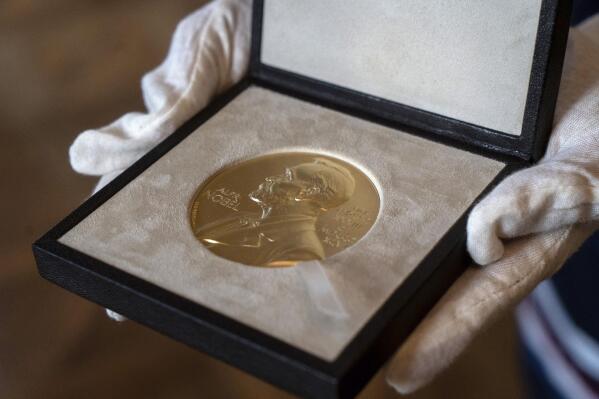 FILE  - In this Tuesday, Dec. 8, 2020 file photo, a view of the medal to be presented to Nobel Laureate in Physics Roger Penrose from the Swedish ambassador to the UK Torbjorn Sohlstrom at the ambassador's residence in London. The Nobel Prize ceremonies will be reined in for a second year due to the coronavirus pandemic. The winners of this year’s prizes in chemistry, literature, physics, medicine and economics, as well as the Nobel Peace Prize, are set to be announced between Oct. 4 and Oct. 11, 2021.  (Niklas Halle'n/Pool via AP, File)
