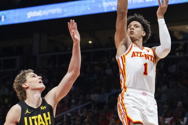 Atlanta Hawks forward Jalen Johnson (1) shoots against Utah Jazz forward Lauri Markkanen (23) during the second half of an NBA basketball game Tuesday, Feb. 27, 2024, in Atlanta. (AP Photo/Hakim Wright Sr.)