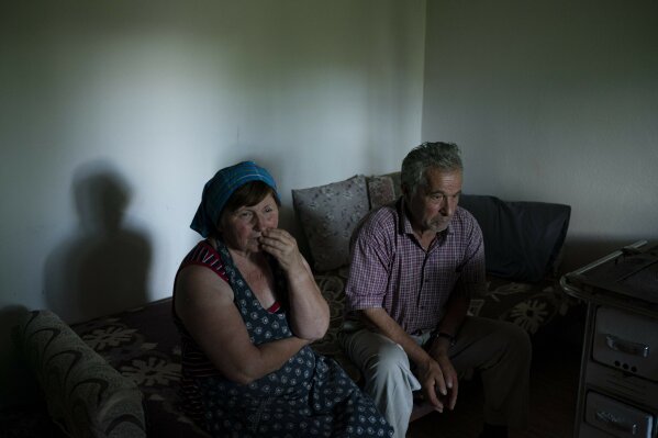 In this June 19, 2019 photo, Jorgji Ilia, 71, a retired schoolteacher, sits with his wife, Vito, 64, inside their home in the village of Kanikol, Albania. "There is nothing else better than the river," he says. "The Vjosa gives beauty to our village." (AP Photo/Felipe Dana)
