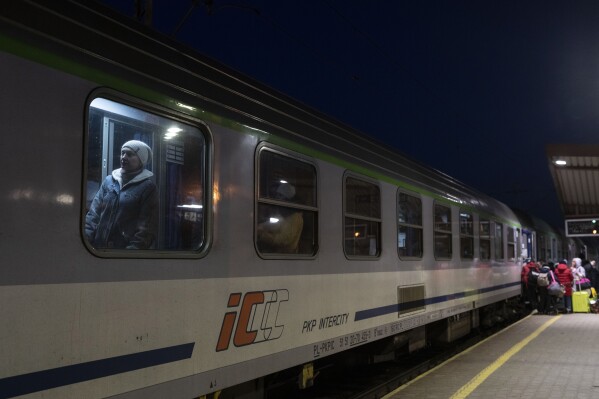 FILE - Ukrainian refugees embark a train bound to Warsaw, at the Przemysl train station, southeastern Poland, on March 11, 2022. Polish security authorities are investigating multiple cases of disruption to railway traffic, after unauthorized radio signals stopped several trains over the weekend. On some of the signals, the Russian national anthem could reportedly be heard in the background. (AP Photo/Petros Giannakouris, File)