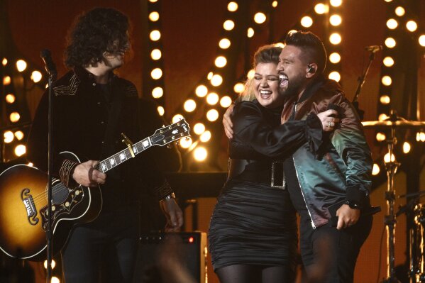 
              Dan Smyers, left, and Shay Mooney, right, of Dan + Shay, and Kelly Clarkson react after performing "Keeping Score" at the 54th annual Academy of Country Music Awards at the MGM Grand Garden Arena on Sunday, April 7, 2019, in Las Vegas. (Photo by Chris Pizzello/Invision/AP)
            