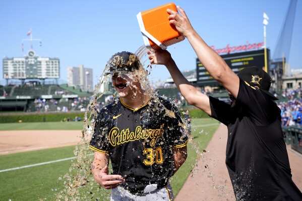 Pittsburgh Pirates starting pitcher Paul Skenes is doused by Martín Pérez during a television interview after the team's win over the Chicago Cubs in a baseball game Friday, May 17, 2024, in Chicago. (AP Photo/Charles Rex Arbogast)