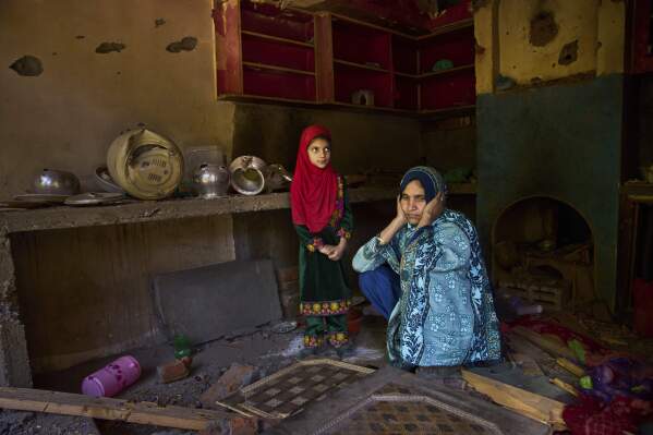 Shreena Begum and her daughter Safeena Banoo sit in their kitchen damaged by artillery shelling from Pakistan in the border village of Gingal, north of Srinagar, Indian-controlled Kashmir, Wednesday, May 14, 2025. (AP Photo/Dar Yasin)