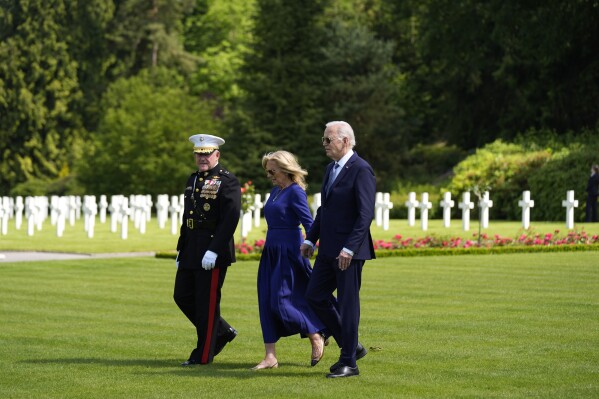 U.S. President Joe Biden and First Lady Jill Biden walk with Major General Robert B. Sofge Jr. as they attend a wreath laying ceremony at the Aisne-Marne American World War One Cemetery in Belleau, France, Sunday, June 9, 2024. (AP Photo/Evan Vucci)