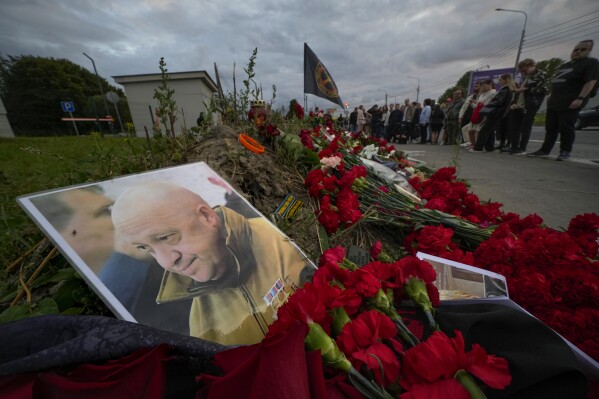 A portrait of the owner of private military company Wagner Group Yevgeny Prigozhin lays at an informal memorial next to the former 'PMC Wagner Centre' in St. Petersburg, Russia, Thursday, Aug. 24, 2023. Russia's civil aviation agency says mercenary leader Yevgeny Prigozhin was aboard a plane that crashed north of Moscow. (AP Photo/Dmitri Lovetsky)