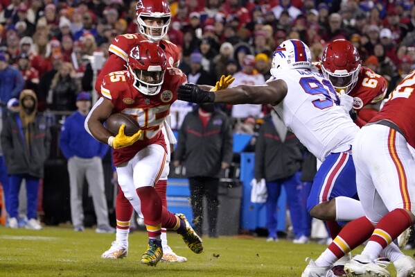Kansas City Chiefs running back Clyde Edwards-Helaire (25) runs with the ball as Buffalo Bills defensive tackle Ed Oliver (91) defends during the second half of an NFL football game Sunday, Dec. 10, 2023, in Kansas City, Mo. (AP Photo/Ed Zurga)