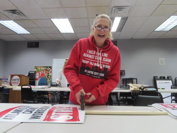 Ruth Ann Joyce, a bartender at the Harrah's and Hard Rock casinos in Atlantic City, N.J. assembles "On Strike" signs at the Atlantic City headquarters of Local 54 of the Unite Here union on Tuesday, June 28, 2022. (AP Photo/Wayne Parry)