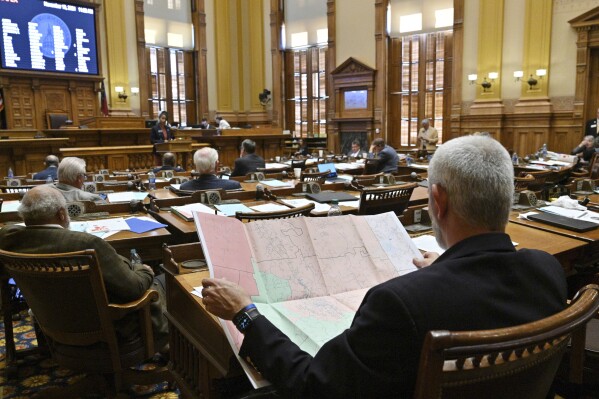 FILE - Chuck Payne, R-Dalton, foreground, looks at a map as Nikki Merritt, D-Grayson, background, speaks in opposition of Senate Bill 2EX, newly-drawn congressional maps, in the Senate Chambers during a special session at the Georgia State Capitol in Atlanta, Nov. 19, 2021. Lawmakers will return on Wednesday, Nov. 29, 2023, for a special session to redraw congressional and legislative maps after a federal judge ruled Georgia's maps illegally diluted the power of Black voters. (Hyosub Shin/Atlanta Journal-Constitution via AP, File)