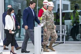 Florida Governor Ron DeSantis arrives at the Miami Beach Convention Center to discuss the Army Corps' building of a coronavirus field hospital inside the facility on Wednesday, April 8, 2020.(Al Diaz/Miami Herald via AP)