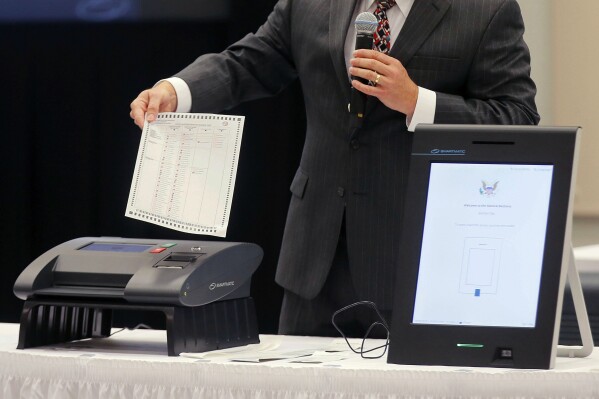 FILE - A Smartmatic representative demonstrates his company's system, which has scanners and touch screens with printout options, at a meeting of the Secure, Accessible & Fair Elections Commission, Aug. 30, 2018, in Grovetown, Ga. On Tuesday, Jan. 23, 2024, a judge refused to toss out Fox News' claims that voting technology company Smartmatic is suing the network to suppress free speech, meaning that both Smartmatic's multibillion-dollar defamation lawsuit and the network's counterclaims can continue toward an eventual trial. (Bob Andres/Atlanta Journal-Constitution via AP, File)