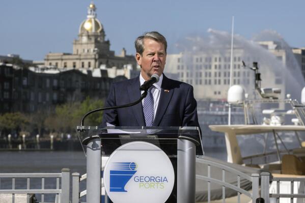 In this photo provided by the Georgia Ports Authority, Georgia Gov. Brian Kemp speaks at a ceremony marking completion of the Savannah Harbor deepening, Friday, March 25, 2022, in Savannah, Ga. Deepening the Savannah Harbor to 47 feet at mean low water (the average depth at low tide), provides ample draft for vessels carrying 16,000+ twenty-foot equivalent container units, allowing ships to transit the river with more containers each trip and during more hours of the day. (AP Photo/Georgia Ports Authority, Stephen Morton)