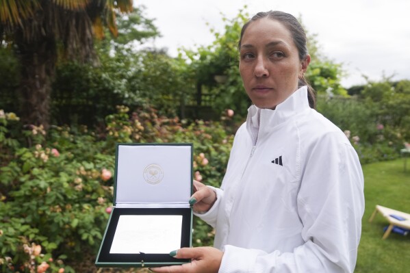 Jessica Pegula of the United States holds the sterling silver plaques players receive at Wimbledon in London, Sunday, June 30, 2024.In a relatively well-kept secret — even some athletes were completely unaware when asked about the keepsakes by The Associated Press during the tournament that wraps up next weekend — the All England Club distributes the mementos to all 256 players in the women's and men's singles brackets, as well as those in doubles and wheelchair events. (AP Photo/Mosa'ab Elshamy)