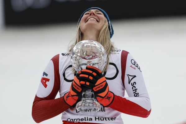 Austria's Cornelia Huetter holds the women's World Cup downhill discipline trophy after completing an alpine ski women's World Cup downhill, in Saalbach, Austria, Saturday, March 23, 2024. (AP Photo/Alessandro Trovati)
