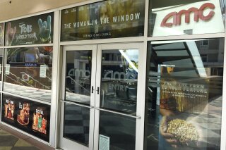 FILE - The front entrance to the currently closed AMC Burbank 16 movie theaters complex is pictured on April 29, 2020, in Burbank, Calif. AMC Theatres and Universal Studios on Tuesday announced an agreement for a shortened theatrical window, with the studio's films playing for a minimum of just 17 days in cinemas. The agreement repaired a rift between AMC and Universal brought on by the on-demand release of "Trolls World Tour" in April. (AP Photo/Chris Pizzello, File)