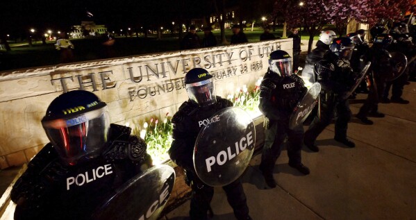 Police stand in front of a University of Utah sign as they move demonstrators who had gathered to show support for the Palestinians off campus at the University of Utah on Monday, April 29, 2024, in Salt Lake City.  (Scott G. Winterton/Deseret News via AP)
