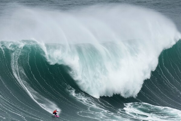 Maya Gabeira, from Brazil, rides a wave during the Nazare Big Wave Challenge surfing tournament at Praia do Norte, or North Beach, in Nazare, Portugal, Monday, Jan. 22, 2024. (AP Photo/Armando Franca)