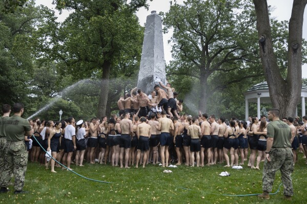 Class of 2027 plebes climb during the Herndon Monument Climb at the U.S. Naval Academy, Wednesday, May 15, 2024, in Annapolis, Md. Freshmen, known as Plebes, participate in the climb to celebrate finishing their first year at the academy. The climb was completed in two hours, nineteen minsters and eleven seconds to complete. (AP Photo/Tom Brenner)