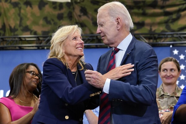 FILE - First lady Jill Biden looks at President Joe Biden as he holds the pen he used to sign an executive order aimed to bolster job opportunities for military and veteran spouses during a visit to Fort Liberty, N.C., June 9, 2023. President Joe Biden's administration has announced new steps to improve a program that lets federal employees who also are military spouses telework from overseas. The steps are part of Jill Biden's work to support military and veteran families. (AP Photo/Susan Walsh, file)