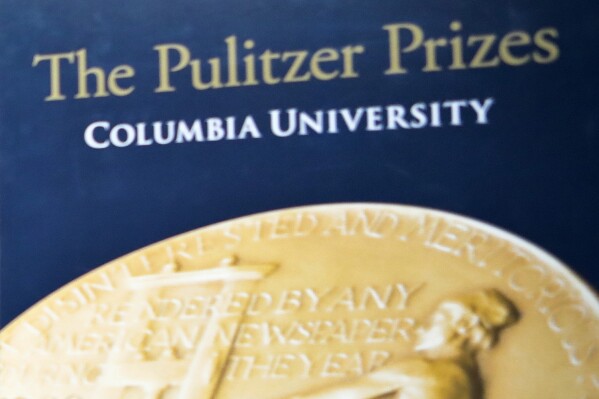 FILE - A sign for the Pulitzer Prize is shown at Columbia University, May 28, 2019, in New York. The Pulitzer Prizes, considered the premier award for print journalists, are opening eligibility to broadcast and audio companies that also offer digital news sites. But the work these companies can submit for prize consideration must primarily be written journalism, the Columbia University-based Pulitzer Prize Board said on Monday, Nov. 6, 2023. (AP Photo/Bebeto Matthews, File)