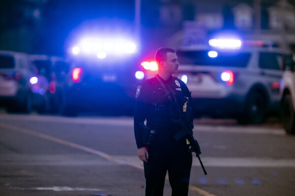 FILE - Police work at the scene of a shooting at New Hampshire Hospital Friday, Nov. 17, 2023. Court records show that John Madore, who fatally shot a security guard at a New Hampshire psychiatric hospital moments before being killed by a state police trooper was not allowed to have guns, ammunition, or any other dangerous weapons following an arrest in 2016. (Geoff Forester/The Concord Monitor via AP, File)
