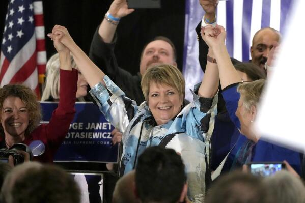 Supreme Court candidate Janet Protasiewicz, center, holds hands with Wisconsin Supreme Court Justice, Rebecca Dallet, far left, and Wisconsin Supreme Court Justice Ann Walsh Bradley, right, at Protasiewicz's election night watch party in Milwaukee, Wis., on Tuesday, April 4, 2023. Protasiewicz, 60, defeated former Justice Dan Kelly, who previously worked for Republicans and had support from the state’s leading anti-abortion groups. (Mike De Sisti /Milwaukee Journal-Sentinel via AP)