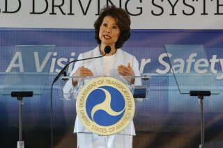 FILE - In this Sept. 12, 2017 file photo,  U.S. Transportation Secretary Elaine Chao announces new voluntary safety guidelines for self-driving cars during a visit to an autonomous vehicle testing facility at the University of Michigan, in Ann Arbor, Mich.  The Trump administration announced its most recent round of guidelines for autonomous vehicle makers, continuing to rely on the industry to police itself despite calls for specific regulations.  Chao announced the proposed guidelines in a speech Wednesday, Jan. 8, 2020 at the CES gadget show in Las Vegas, saying in prepared remarks that “AV 4.0” will ensure U.S. leadership in developing new technologies.(Hunter Dyke/The Ann Arbor News via AP, File)