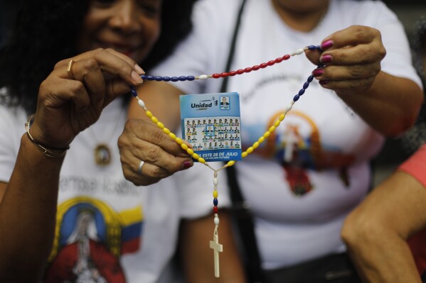 Opposition supporters hold a rosary with a flyer showing presidential candidate Edmundo Gonzalez during a prayer event in Caracas, Venezuela, Sunday, July 21, 2024. Venezuela is set to hold presidential elections July 28. (ĢӰԺ Photo/Cristian Hernandez)