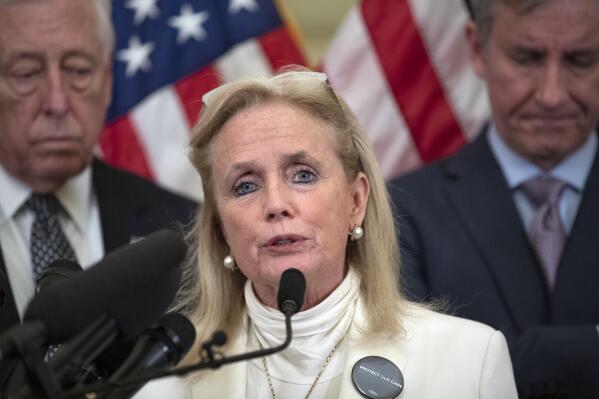FILE - In this Feb. 4, 2020 file photo, Rep. Debbie Dingell, D-Mich., center, speaks accompanied by House Majority Leader Steny Hoyer of Md., left, and Rep. Matt Cartwright, D-Pa., during a news conference on healthcare, on Capitol Hill in Washington. Dingell says her “belly was on fire” before doctors quickly performed surgery for a perforated ulcer. The Detroit-area Democrat says she expects to stay in a Washington hospital for five to seven days. Dingell says she was planning to fly back to Michigan when pain overwhelmed her Friday, May 21, 2021. (AP Photo/Alex Brandon, File)