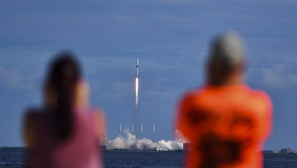 Julie and Doc Todd watch the launch SpaceX from KARS Park in Florida, Monday, Nov. 11, 2019. SpaceX launched 60 mini satellites Monday, the second batch of an orbiting network meant to provide global internet coverage. (Malcolm Denemark/Florida Today via AP)