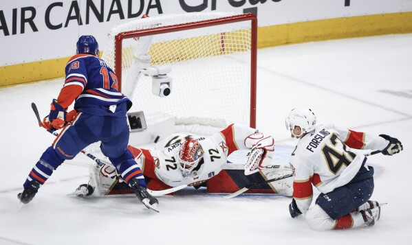 Florida Panthers goalie Sergei Bobrovsky (72) is scored on by Edmonton Oilers' Zach Hyman (18) as Gustav Forsling (42) watches during the second period of Game 6 of the NHL hockey Stanley Cup Final, Friday, June 21, 2024, in Edmonton, Alberta. (Jeff McIntosh/The Canadian Press via AP)
