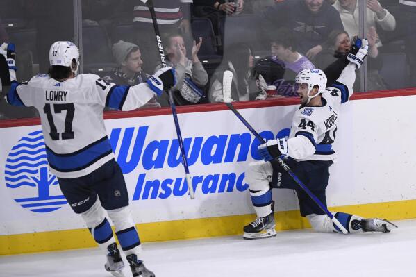 Winnipeg Jets' Josh Morrissey (44) celebrates after his winning goal against the Carolina Hurricanes with Adam Lowry (17) during overtime in NHL hockey game action in Winnipeg, Manitoba, Monday, Nov. 21, 2022. (Fred Greenslade/The Canadian Press via AP)