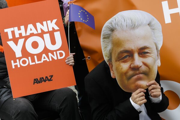 
              An activist of the AVAAZ network with a mask of Dutch anti-Islam lawmaker Geert Wilders attends an event to celebrate the election results in the Netherlands in front of the Brandenburg Gate in Berlin, Thursday, March 16, 2017. (AP Photo/Markus Schreiber)
            