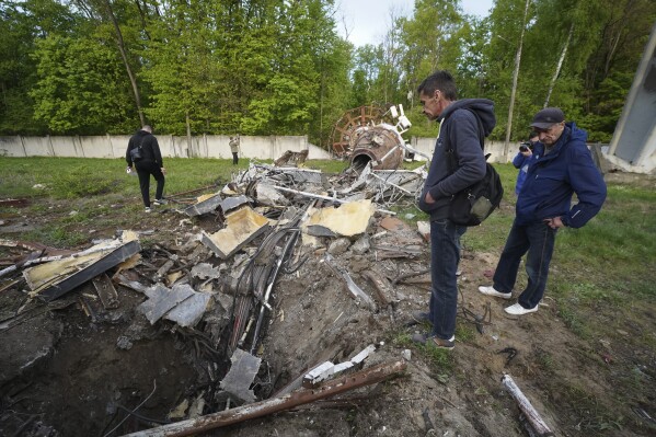 Gente mirando restos de una torre de televisión que quedó rota por la mitad tras ser alcanzada por un misil ruso en Járkiv, Ucrania, el lunes 22 de abril de 2024 (AP Foto/Andrii Marienko)
