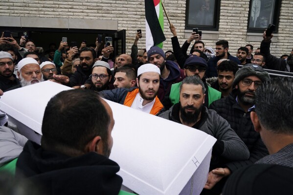 Family members of Wadea Al Fayoume bring out his casket from Mosque Foundation to the hearse in Bridgeview, Ill., Monday, Oct. 16, 2023. An Illinois landlord accused of fatally stabbing the 6-year-old Muslim boy and seriously wounding his mother was charged with a hate crime after police and relatives said he singled out the victims because of their faith and as a response to the war between Israel and Hamas. (AP Photo/Nam Y. Huh)