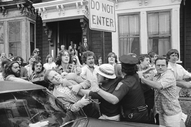FILE - Police officers break up a scuffle amid demonstrators outside South Boston High School on the first day of a court-ordered busing program to integrate Boston public schools, Sept. 12, 1974. Seventy years after the Supreme Court's Brown v. Board, America is both more diverse — and more segregated. (AP Photo/Peter Bregg, File)