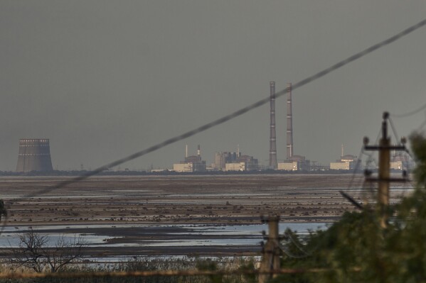 FILE - The Zaporizhzhia nuclear power plant, Europe's largest, is seen in the background of the shallow Kakhovka Reservoir after the dam collapse, in Energodar, Russian-occupied Ukraine, Tuesday, June 27, 2023. The U.N. atomic watchdog said in a statement late Monday, July 24, 2023, its staff at Ukraine’s Russian-occupied Zaporizhzhia Nuclear Power Plant report seeing anti-personnel mines around the site. The report comes as Kyiv pursues a counteroffensive against the Kremlin’s entrenched forces after 17 months of war. (AP Photo/Libkos, File)