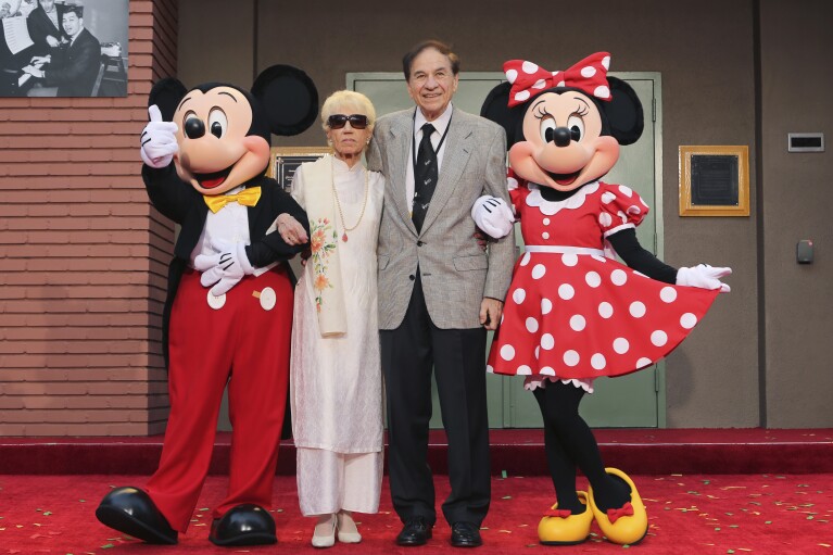 FILE - Mickey Mouse, from left, Elizabeth Gluck, Richard M. Sherman and Minnie Mouse pose for a photo at the ceremony honoring the Sherman Brothers with the rename of Disney Studios Soundstage A at the world premiere of Disney's 